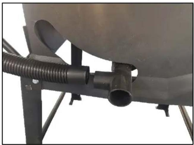 Close-up of a mechanical pipe fitting with black tubing and a cylindrical component (no visible text or symbols)
