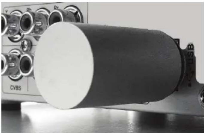 Close-up of a cylindrical electronic device with labeled ports (CVBS, Qh, Qr) and no visible text or symbols on the body.