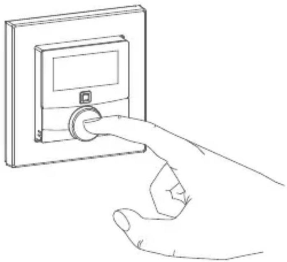 Line drawing of a hand inserting a digital camera into a wall-mounted device (no text or symbols)