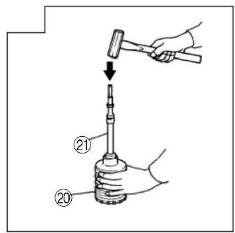 Diagram showing a hand using a hammer to press a mechanical component, labeled with parts 20 and 21.