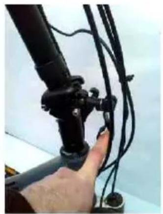 Close-up of a hand holding a black mechanical device with wires attached (no visible text or symbols)