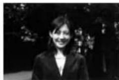 Black-and-white photo of a woman in formal attire standing outdoors (no visible text or symbols).