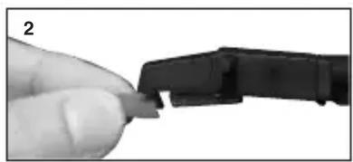 Close-up of a hand holding a small black connector or plug, with no visible text or symbols.
