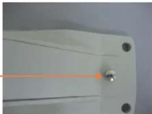 Close-up of a white mechanical component with a central orange laser beam and two black circular holes (no text or symbols visible)