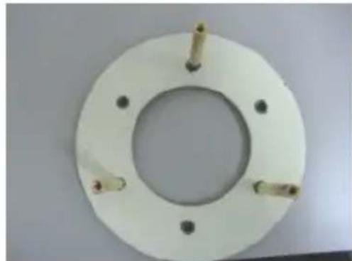 Circular white mechanical flange with four bolt holes and central hole, no text or symbols visible