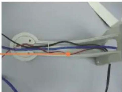 Close-up of a mechanical linkage with wires and a central circular component (no visible text or symbols)