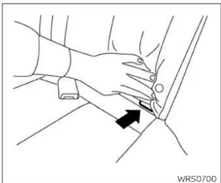 Line drawing of a hand pressing down on a car seatbelt, with a black arrow indicating the motion direction (no text or symbols)