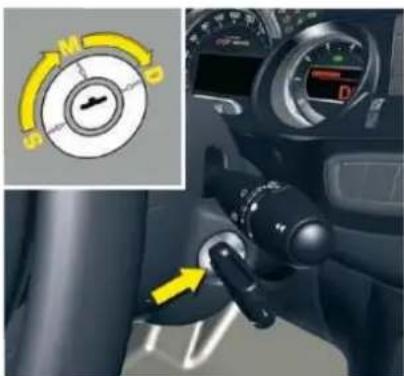 Car dashboard control panel with directional dial indicator and yellow arrow pointing to a specific mode
