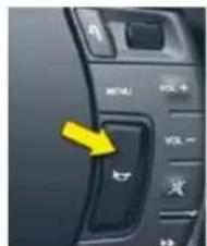 Close-up of a computer control panel with labeled buttons and a yellow arrow pointing to the button.