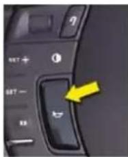 Close-up of a computer control interface with labeled buttons and a yellow arrow pointing to the right button.