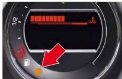 Close-up of a car dashboard dial showing red indicator lights and a red arrow pointing to a small orange button.
