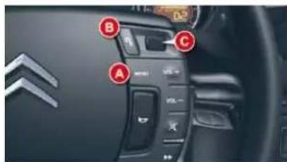 Car interior control panel with labeled buttons A, B, and C, showing brand logo and vehicle status indicators