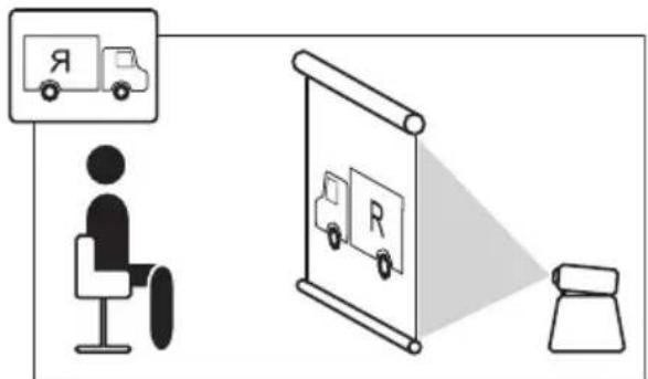 Diagram illustrating a person sitting at a desk facing a truck-mounted display screen, with a magnifying glass showing the same truck and a small object nearby.