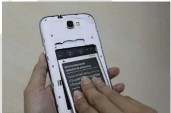 Hand holding smartphone displaying a mobile app interface with Chinese text and URL