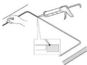 Simple line drawing of a hand holding a tool with a bracket and a small inset showing a grid pattern (no text or symbols)