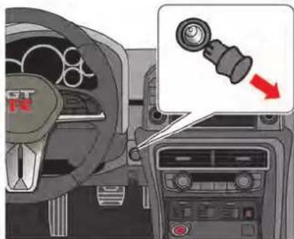 Interior view of a car dashboard with steering wheel and control panel, showing a close-up of the gear shift (no text or symbols visible)