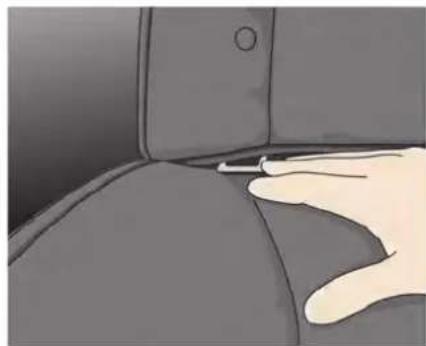 Close-up of a hand pressing down on a car seat (no text or symbols visible)