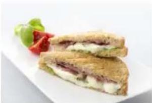 Close-up of a sandwich with lettuce and tomato garnish on a white plate (no text or symbols visible)