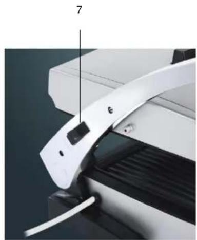 Close-up of a white electronic device with a curved handle and a black panel, showing mechanical components (no visible text or symbols)