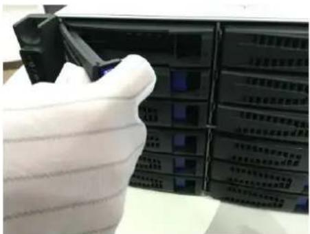 Close-up of a hand holding a white hard hat, partially obscured by a device panel with Chinese text labels.