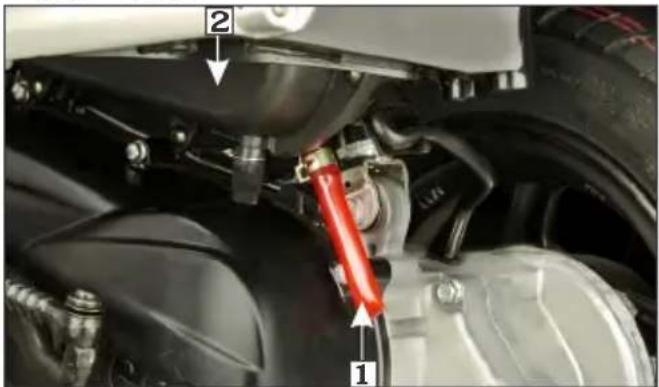 Close-up mechanical assembly diagram with numbered components and red warning label