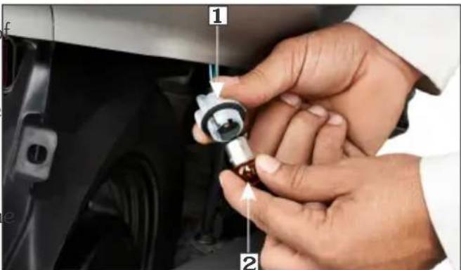 Close-up of hands installing a component with numbered callouts (1 and 2) on the car's side panel.