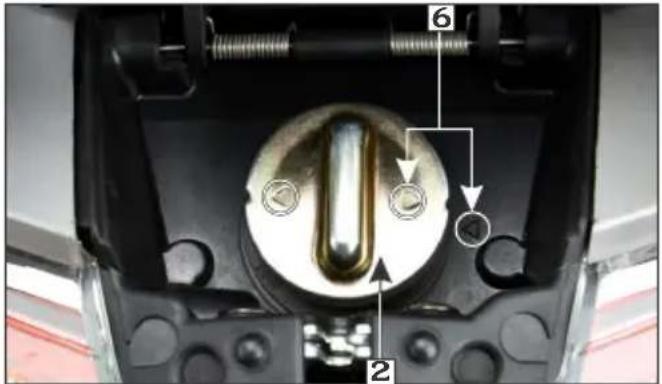 Close-up of a mechanical component with numbered parts and directional arrows indicating motion or assembly.