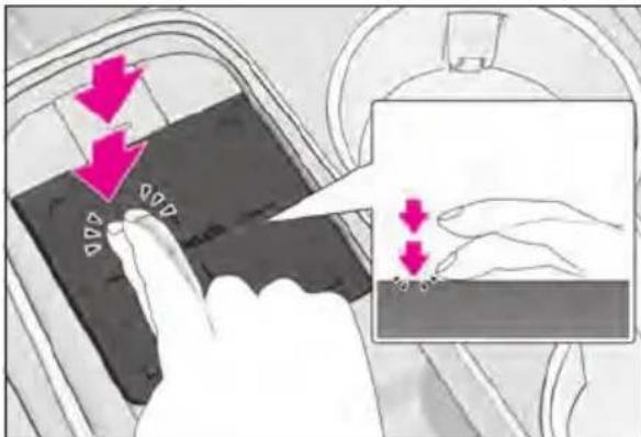 Diagram showing hand positioning of a device with directional arrows and magnified view highlighting movement or positioning.