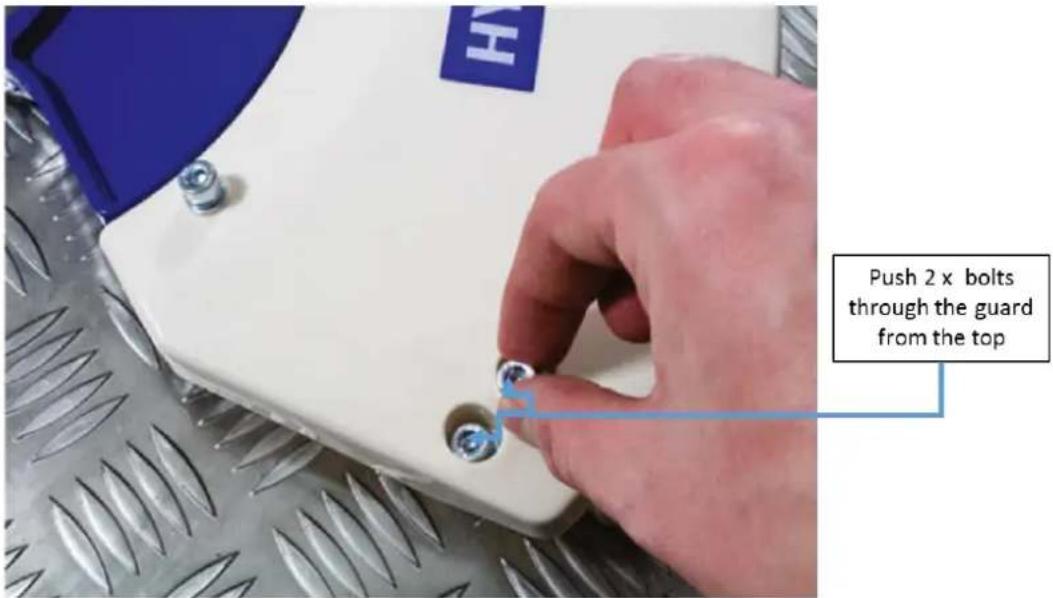 Push 2 x bolts through the guard from the top