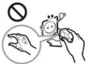 Safety warning illustration showing hand holding a device with no stop symbol and magnified view of contact area