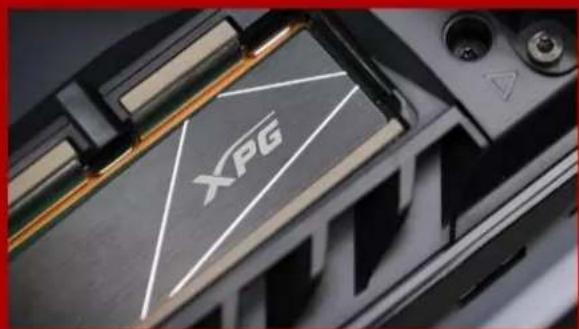 Close-up of a 3D printer's internal structure with XPG logo and warning symbol (no readable text beyond logo)