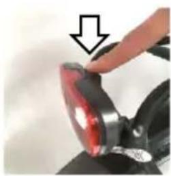 Close-up of a hand pressing a red-lit circular object with a downward arrow, no visible text or symbols