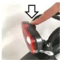 Close-up of a hand pressing a red circular object on a mechanical component (no text or symbols visible)