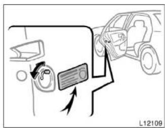 Diagram showing car interior and driver's seatbelt, with a car door and directional arrow indicating movement or movement.