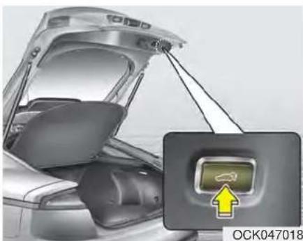 Interior view of a car trunk with open lid and attached seatbelt, showing a small inset image of the airplane inside (no text or symbols on main subject)