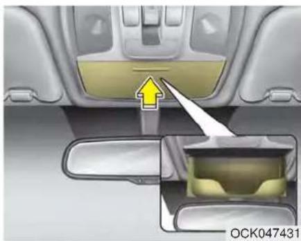 Interior view of a car showing dashboard and side mirror with a yellow arrow pointing to the dashboard (no text or symbols)