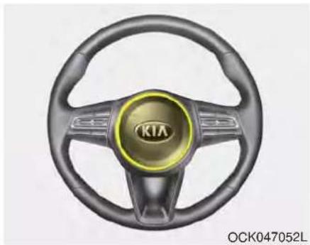 Interior view of a car steering wheel with visible brand logo (KIA) and branding text below
