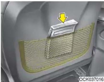 Interior view of a car showing a mesh partition and a yellow arrow pointing to a component (no text or symbols)