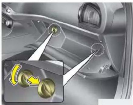 Interior view of a car showing a knob adjustment mechanism with an inset close-up of two yellow-green buttons (no text or symbols)