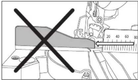 Technical diagram showing a tool with a cross mark and a ruler measuring a length, likely indicating measurement or alignment.