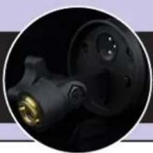 Close-up of a black mechanical component with a golden bulb, possibly a valve or pump, against a dark background (no visible text or symbols)