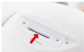 Close-up of a white electronic device with a red arrow pointing to a slot (no visible text or symbols)