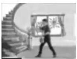 Black-and-white photo of a person walking past a staircase with a window and plant (no visible text or symbols)