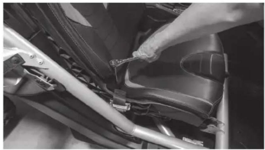 Close-up of a hand adjusting a car seatbelt component (no visible text or symbols)