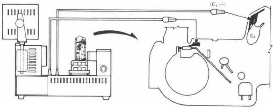 Technical diagram showing a mechanical device connected to a device with labeled components and directional arrows indicating motion or assembly.