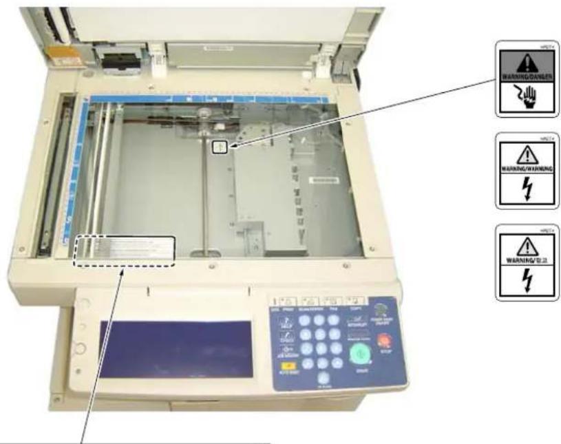 Diagram of an industrial machine with warning icons and labeled control panel, showing internal components and warning labels.