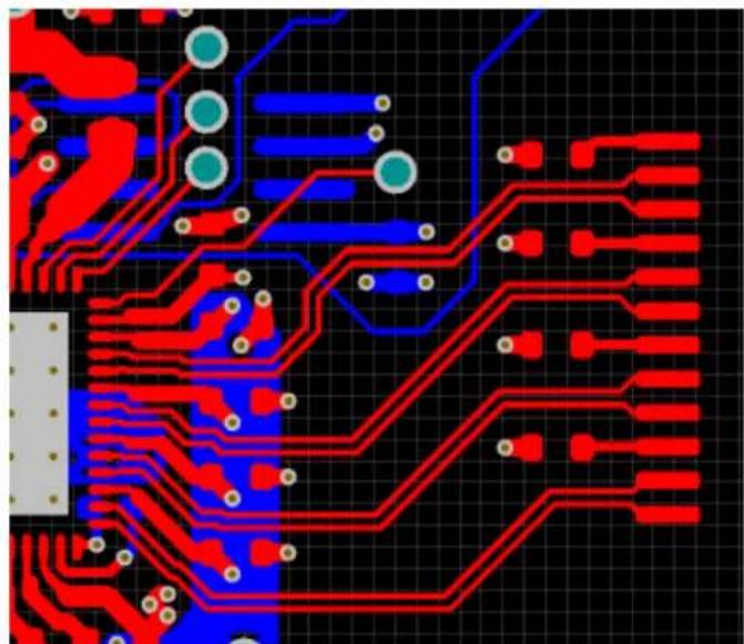 Close-up of a printed circuit board with red and blue traces on a black grid background (no text or symbols)