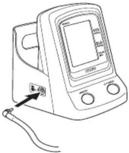 Line drawing of a blood pressure monitor with labeled ports and a cable, showing measurement scale and pointer.