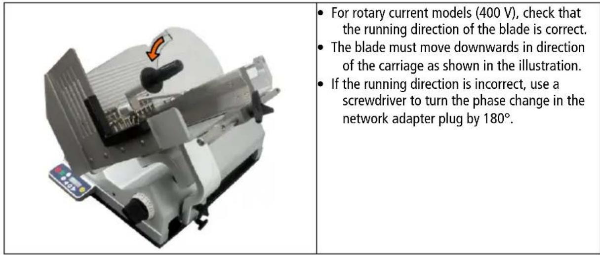 For rotary current models (400 V), check that the running direction of the blade is correct. The blade must move downwards in direction of the carriage as shown in the illustration. If the running direction is incorrect, use a screwdriver to turn the phase change in the network adapter plug by 180°.