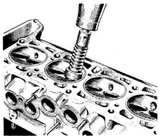 Technical illustration of an engine cylinder head with a screw inserted, showing internal components (no text or labels)